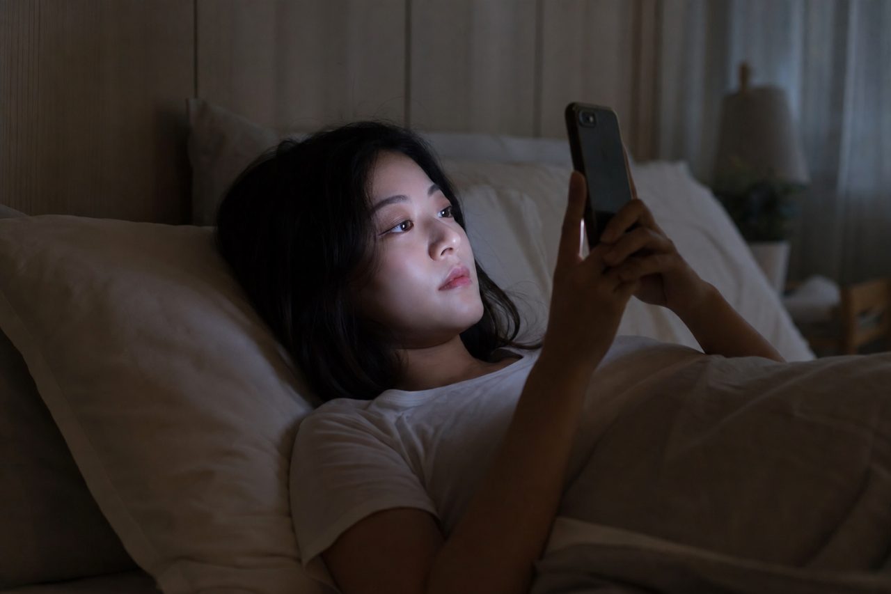 어두운 방에서 밝은 스마트폰 화면을 보는 모습은 숙면을 방해할 수 있다.